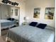 Bedroom featuring a comfortable bed with blue bedding, a side table, wall art, and mirrored closet doors at 6832 Sw 93Rd Ave, Ocala, FL 34481