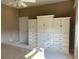 Bedroom featuring built-in closet and dresser with white cabinets and drawers, plus a door to the side at 6832 Sw 93Rd Ave, Ocala, FL 34481
