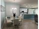 Open concept dining area features a glass top table and white upholstered chairs, adjacent to the kitchen at 6832 Sw 93Rd Ave, Ocala, FL 34481