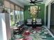 Comfortable sunroom with large windows, armchairs, a ceiling fan, and stylish floral rug at 6832 Sw 93Rd Ave, Ocala, FL 34481