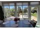 Bright sunroom features large windows overlooking the landscaped yard, a dark table, and seating for four at 6832 Sw 93Rd Ave, Ocala, FL 34481