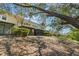 View of a backyard featuring a covered patio, lush greenery, and a serene natural landscape with mature trees at 6936 Hochad Dr, Orlando, FL 32819