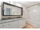 Bright bathroom featuring granite countertops, dual sinks, large mirror, and bathtub with shower at 6936 Hochad Dr, Orlando, FL 32819