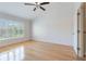 Bright bedroom with hardwood floors, a ceiling fan, and a large window with plantation shutters at 6936 Hochad Dr, Orlando, FL 32819