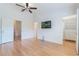 Spacious bedroom with hardwood floors, large closet, wall mounted TV and a ceiling fan at 6936 Hochad Dr, Orlando, FL 32819
