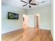Spacious bedroom featuring hardwood floors, ceiling fan, TV, and a private entrance to the bathroom at 6936 Hochad Dr, Orlando, FL 32819