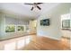 Bright bedroom with hardwood floors, three windows, ceiling fan, walk-in closet, and an ensuite bathroom at 6936 Hochad Dr, Orlando, FL 32819