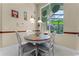 Cozy dining area with natural light, a round table with four chairs, and views of the outdoor living space at 701 Palenci Ct, Winter Springs, FL 32708