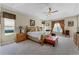 Bright main bedroom offering tray ceilings, a ceiling fan, large windows, and comfortable furnishings at 701 Palenci Ct, Winter Springs, FL 32708