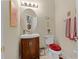 Charming powder room features a pedestal sink with decorative accents and a round mirror at 701 Palenci Ct, Winter Springs, FL 32708
