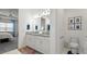 Well-lit bathroom with double sinks, granite countertops, and a view into the main bedroom suite at 7977 Hanson Bay Pl, Kissimmee, FL 34747
