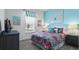 Charming bedroom with a blue accent wall, patterned bedding, and ample natural light at 7977 Hanson Bay Pl, Kissimmee, FL 34747