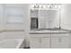 Bathroom with double sinks, granite countertop, large mirror, and bathtub at 8255 Bryce Canyon Ave, Windermere, FL 34786