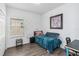 Bright bedroom featuring a bed, a desk and wood-look flooring and natural light from the window at 8255 Bryce Canyon Ave, Windermere, FL 34786