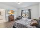 Well-lit bedroom with a mounted TV, bathroom access, and sitting chair at 8255 Bryce Canyon Ave, Windermere, FL 34786