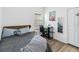 Comfortable bedroom with a bed, a desk and wood-look flooring and natural light from the window and a mirror at 8255 Bryce Canyon Ave, Windermere, FL 34786