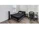 A bright bedroom with a large bed, a desk and wood-look flooring and natural light from the two windows at 8255 Bryce Canyon Ave, Windermere, FL 34786