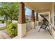 Inviting front porch with sturdy support columns, a swing and lush landscaping around the property at 8255 Bryce Canyon Ave, Windermere, FL 34786