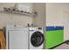 Functional laundry room with modern washer and dryer, shelving, and space-saving ironing board at 9122 Stromboli Ct, Kissimmee, FL 34747