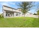 Manicured backyard featuring lush green lawn, privacy fence, and covered patio at 9947 Summerlake Groves St, Winter Garden, FL 34787