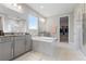 Bright bathroom showcases a large soaking tub, dual vanities, and walk-in shower at 9947 Summerlake Groves St, Winter Garden, FL 34787