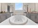A stunning soaking tub is centered between and vanities, and features a large window at 9947 Summerlake Groves St, Winter Garden, FL 34787