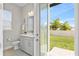 Sun-drenched powder room with vanity, toilet, and door to the home's beautiful backyard at 9947 Summerlake Groves St, Winter Garden, FL 34787