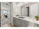 Bright bathroom featuring double sinks with gray cabinetry and modern fixtures at 9947 Summerlake Groves St, Winter Garden, FL 34787