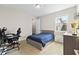 Well-lit bedroom with a comfortable bed, desk, computer, and window, perfect for relaxation or study at 9947 Summerlake Groves St, Winter Garden, FL 34787