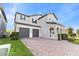 Beautiful two-story home featuring a brick paver driveway, two-car garage, and manicured lawn at 9947 Summerlake Groves St, Winter Garden, FL 34787