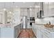 Modern kitchen with stainless steel appliances, granite countertops, and stylish gray cabinets at 9947 Summerlake Groves St, Winter Garden, FL 34787