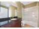 Bathroom features a tub and shower combo with glass doors and a cherry vanity with black top at 11564 Mizzon Dr # 305, Windermere, FL 34786