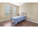 Cozy bedroom features two windows, hardwood floors, and a double bed at 11564 Mizzon Dr # 305, Windermere, FL 34786