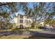 Exterior view of a condo building with two floors and screened patios, surrounded by mature trees at 11564 Mizzon Dr # 305, Windermere, FL 34786