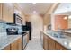 Well-lit kitchen featuring stainless steel appliances, granite counters and wooden cabinets at 11564 Mizzon Dr # 305, Windermere, FL 34786