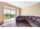 Comfortable living room with a brown sectional sofa and sliding doors to the screened balcony with a pleasant view at 11564 Mizzon Dr # 305, Windermere, FL 34786