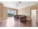 Spacious living room featuring a brown sectional and sliding glass doors leading to a balcony with a wooded view at 11564 Mizzon Dr # 305, Windermere, FL 34786