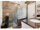 Modern bathroom with tile walls, glass block partition, and double sink vanity at 1296 Bridlebrook Dr, Casselberry, FL 32707