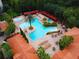 Aerial view of a luxurious pool area with cabanas, lounge chairs, palm trees, and lush landscaping at 1361 Tuscan Ter # 7105, Davenport, FL 33896