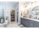 Elegant bathroom featuring double vanity, marble countertops, and a glass-enclosed shower and tub at 1411 Ellis Fallon Loop, Oviedo, FL 32765