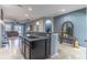 The kitchen island features granite countertops, a sink, and seating for entertaining, flowing into the living area at 1411 Ellis Fallon Loop, Oviedo, FL 32765