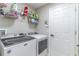 Well-organized laundry room with modern washer and dryer, storage shelves, and white painted door at 1411 Ellis Fallon Loop, Oviedo, FL 32765