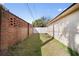 A small backyard featuring a brick fence, white fence, grass, and an aqua bird bath at 1493 Hyde Park Dr, Winter Park, FL 32792