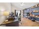 Bright bedroom with wood floors, a ceiling fan, and custom shelves on a blue accent wall at 1493 Hyde Park Dr, Winter Park, FL 32792