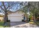 Charming single-story home with white siding, a blue door, and a two-car garage at 1493 Hyde Park Dr, Winter Park, FL 32792