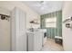 Well-lit laundry room with washer, dryer, storage, and stylish accent wall at 1493 Hyde Park Dr, Winter Park, FL 32792