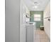 Laundry room with white washer and dryer, bright window and storage at 1493 Hyde Park Dr, Winter Park, FL 32792