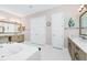 Well-lit bathroom with a soaking tub, double vanity, and neutral decor for a relaxing experience at 15469 Shorebird Ln, Winter Garden, FL 34787