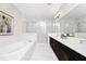 Bathroom featuring a soaking tub, a glass-enclosed shower, and a double sink vanity with dark cabinetry at 15469 Shorebird Ln, Winter Garden, FL 34787