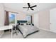 Well-lit bedroom with a teal bed, a modern desk, and comfortable seating, complemented by neutral walls and soft carpet at 15469 Shorebird Ln, Winter Garden, FL 34787